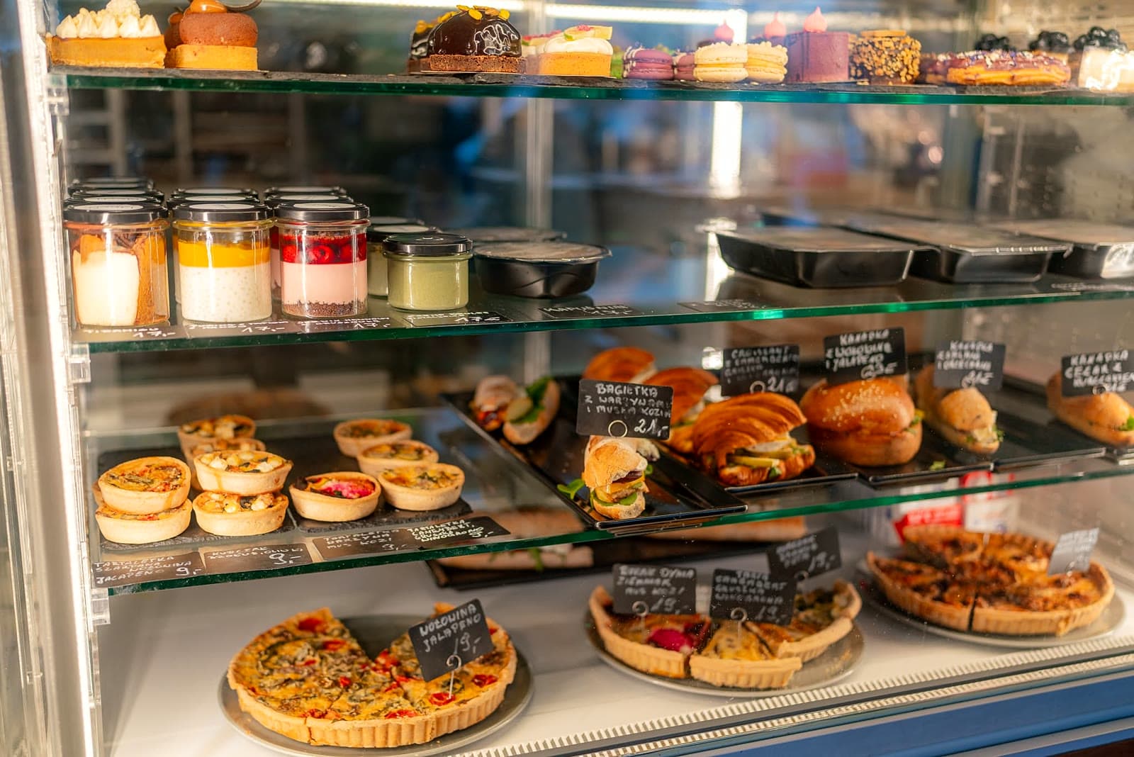 A display case full of fresh tarts, quiches and pastries